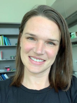 professor wearing a black shirt in front of a bookcase